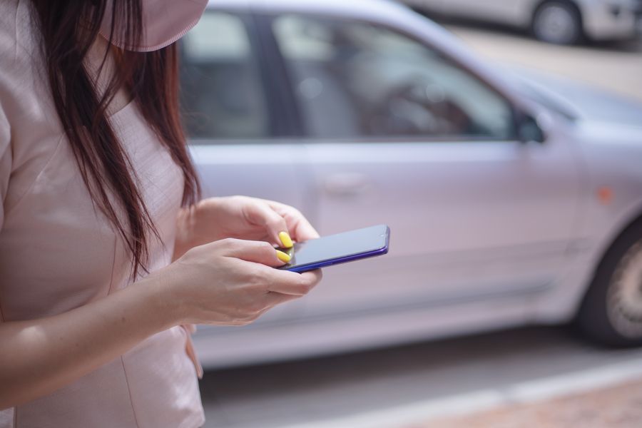 woman in pink blouse texting on a smartphone — De gare en gare à Luxembourg : tout passe par le téléphone.