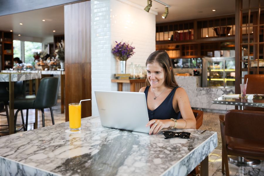 a woman inside a restaurant using a laptop — My Active eSIMs accepts your trip details and hands back a clear recommendation.