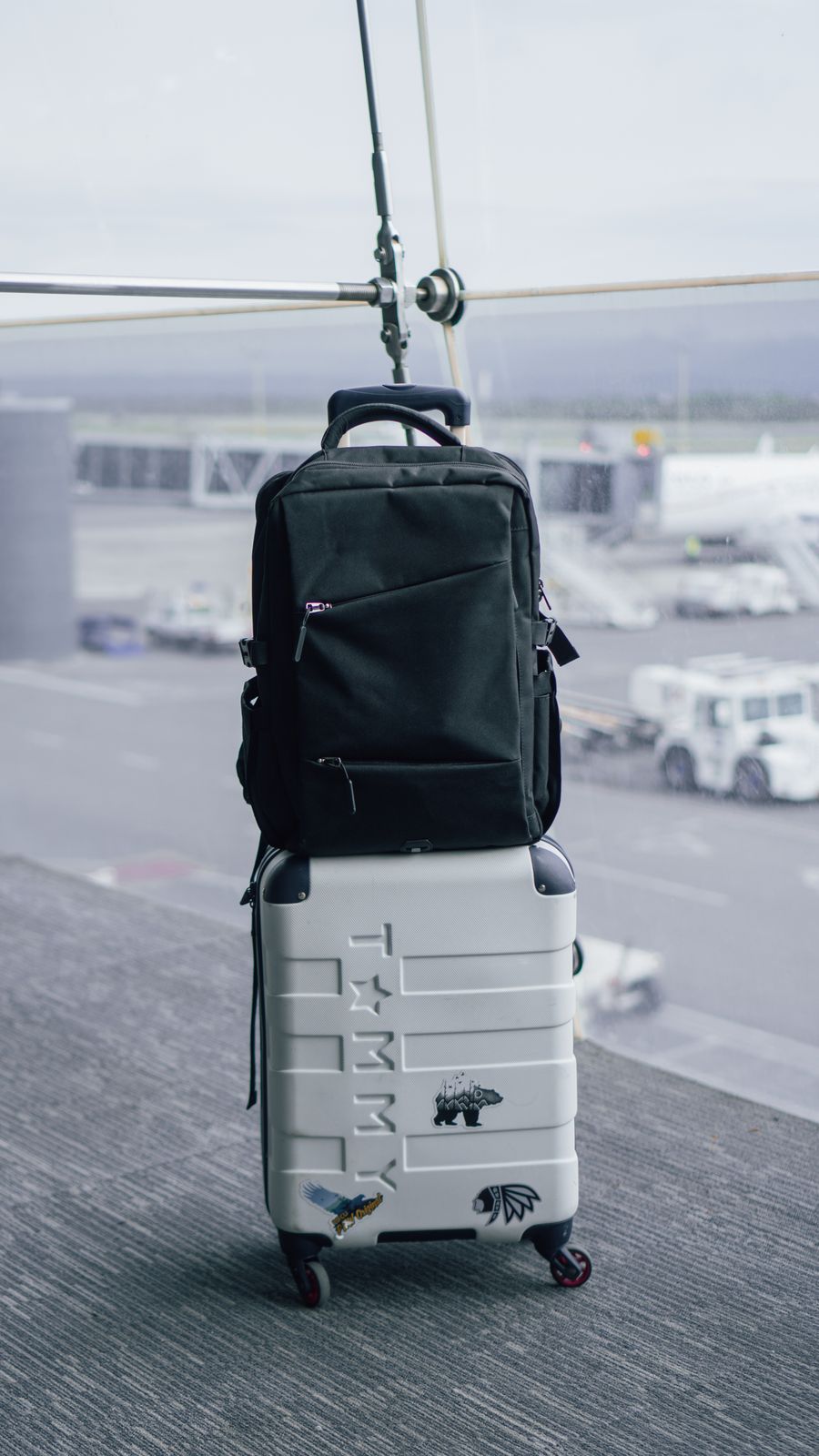 backpack on suitcase on airport — De quai en quai : billets, horaires et taxis dans une main.