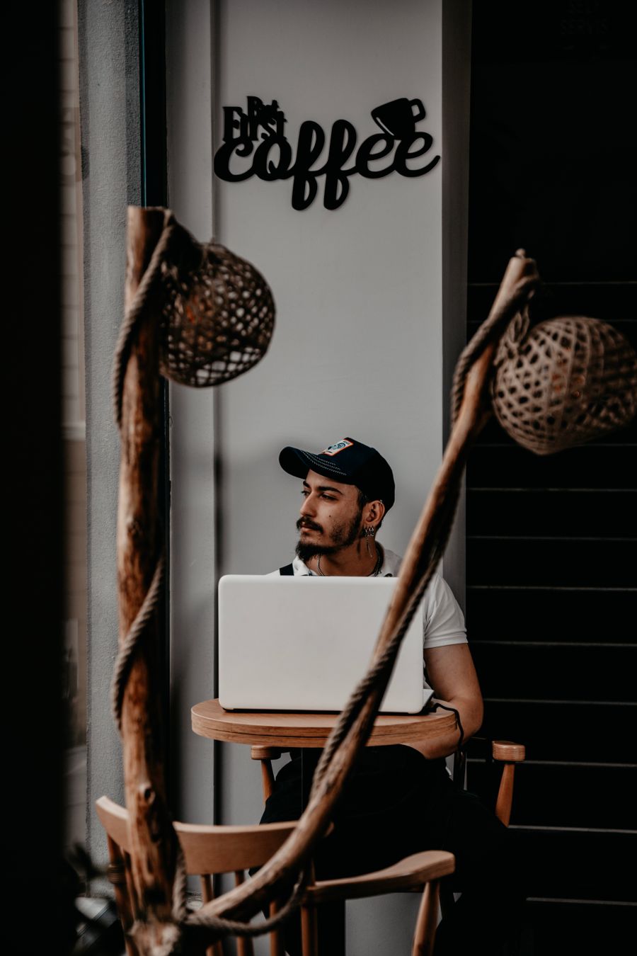 man in cap sitting by table with laptop — Changelog: Lisez le changelog avant le communiqué de presse — il est plus honnête.