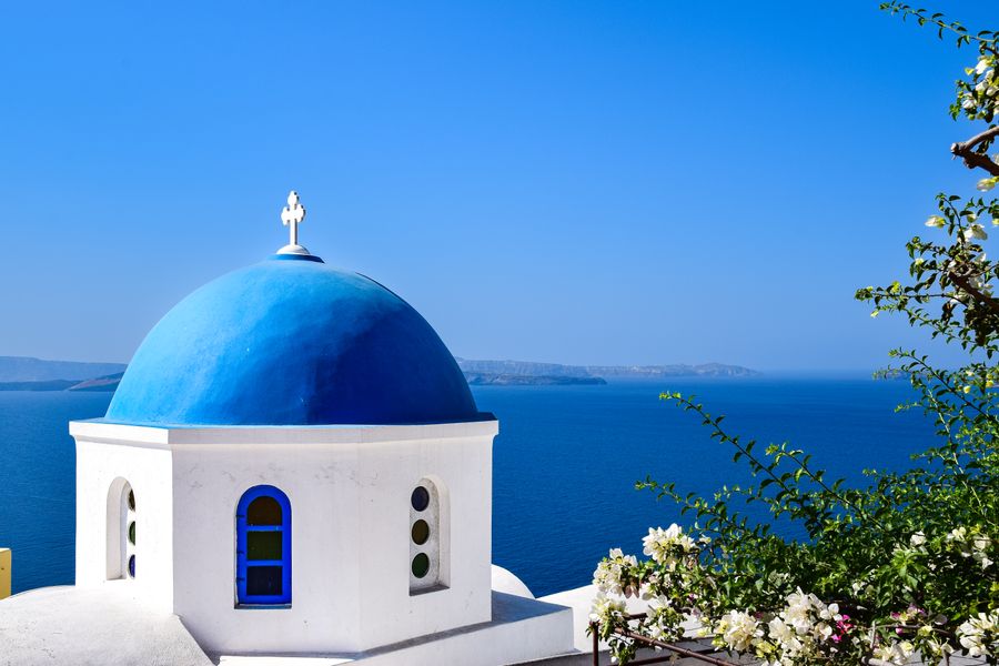 dome of church on sea coast in greece — Le comptoir de location appelle ? Répondez sur place avec votre numéro de voyage.