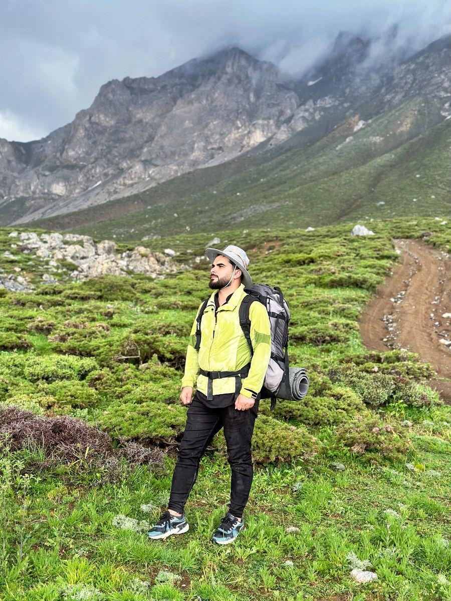 man wearing yellow jacket in a mountain valley — Validated inputs, trip-aware math, plain words — the tool's whole method.