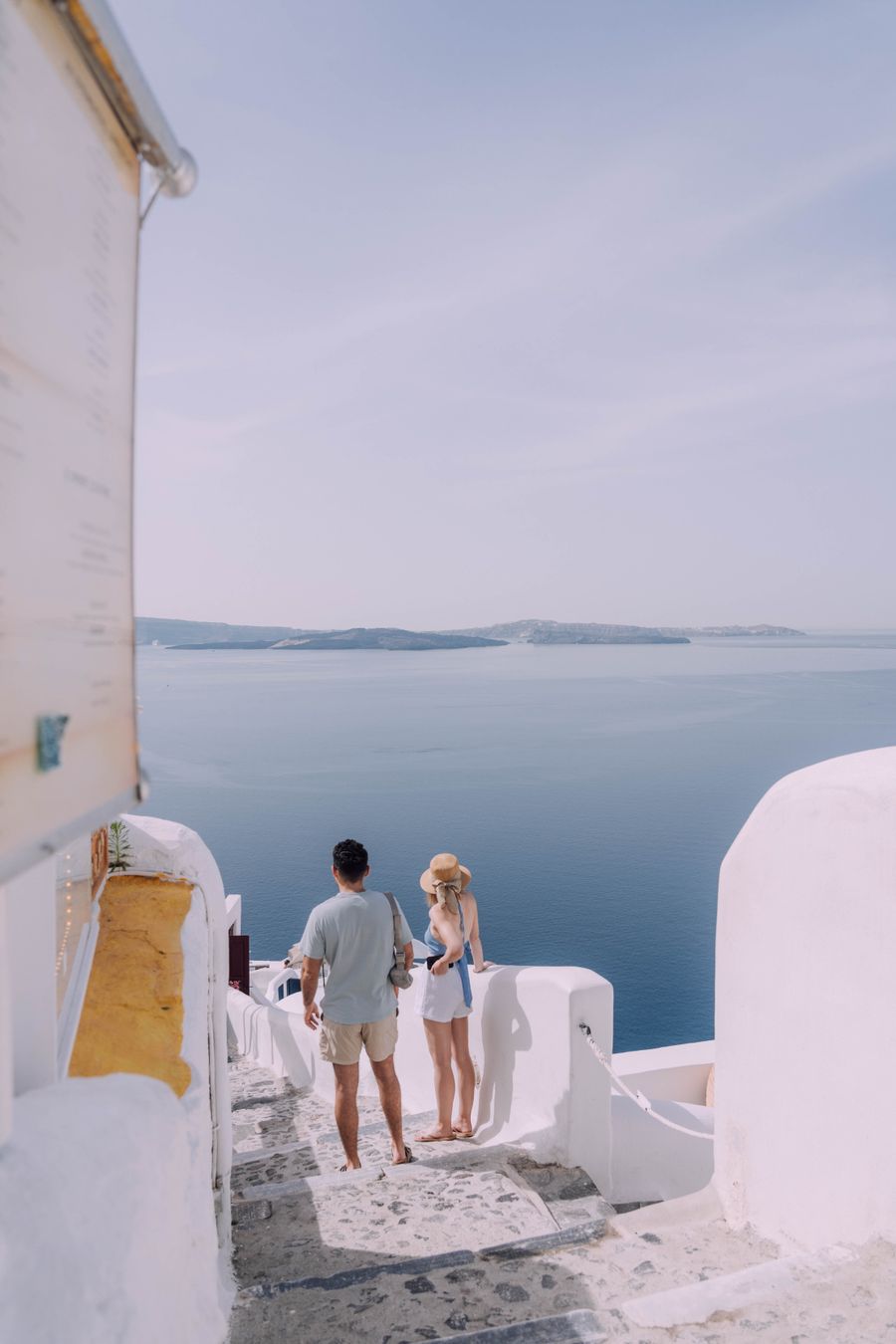couple walking down the stairs in santorini greece