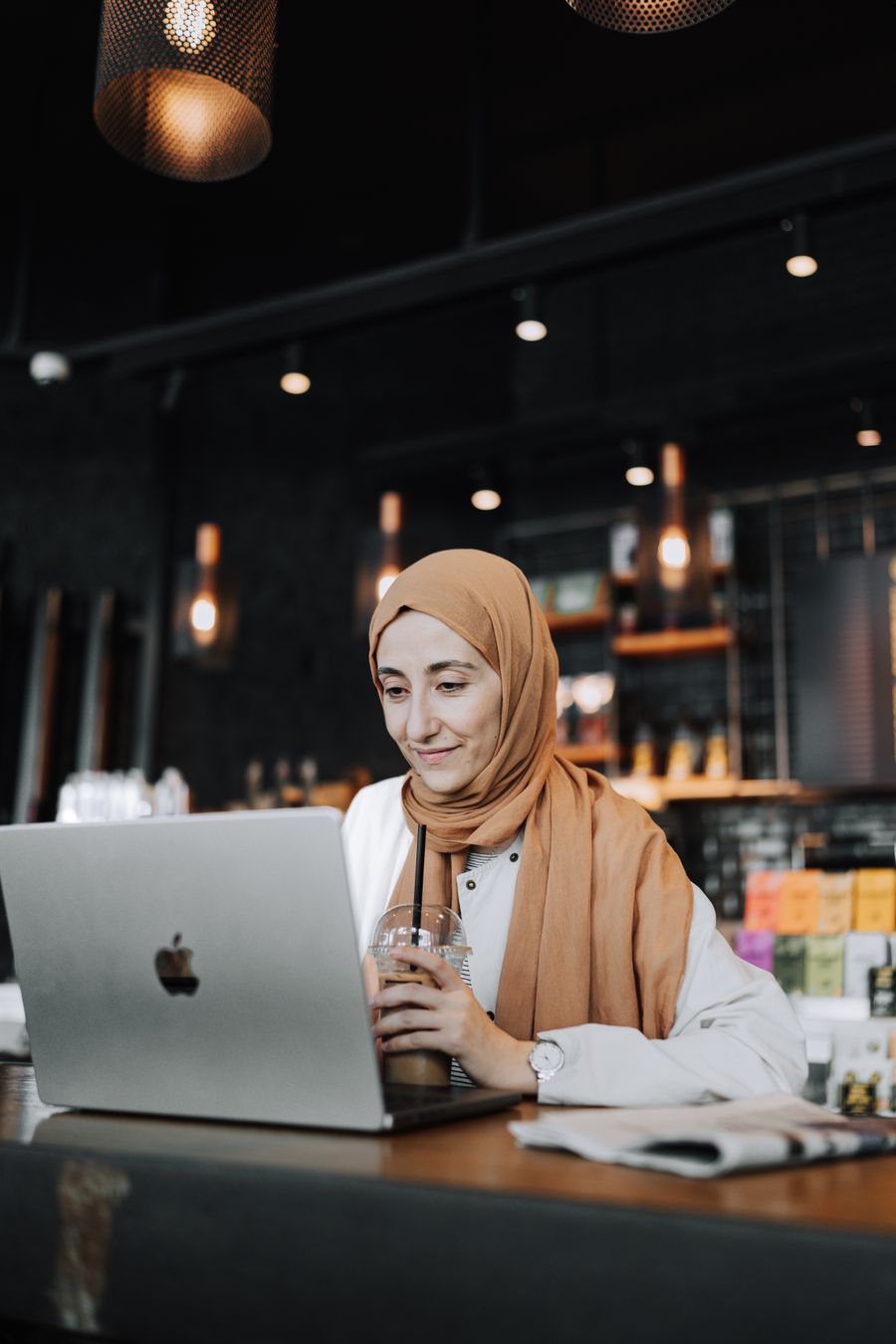 woman using laptop at cafe — Connection Quality Grader: one question, answered well, instead of ten open tabs.