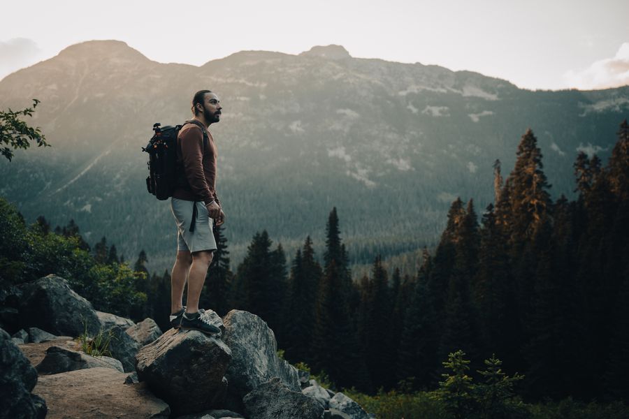 man with a backpack standing on a rock — Soirées à Belgium : dîners, trajets et avis, tout instantané.