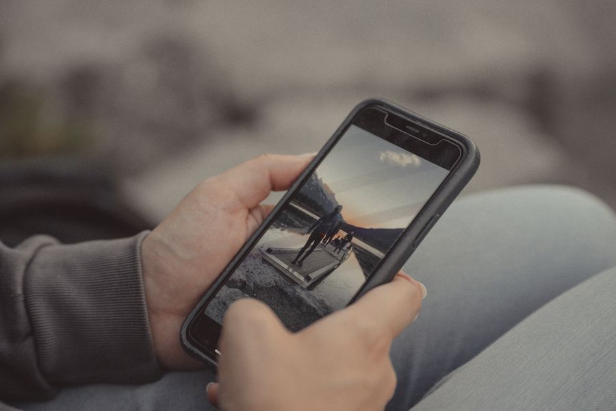 Close-up of hands holding a smartphone showing a mountain scene, captured outdoors in Banff. — Captive Portal Detector links every answer onward — usually the plan it recommends.