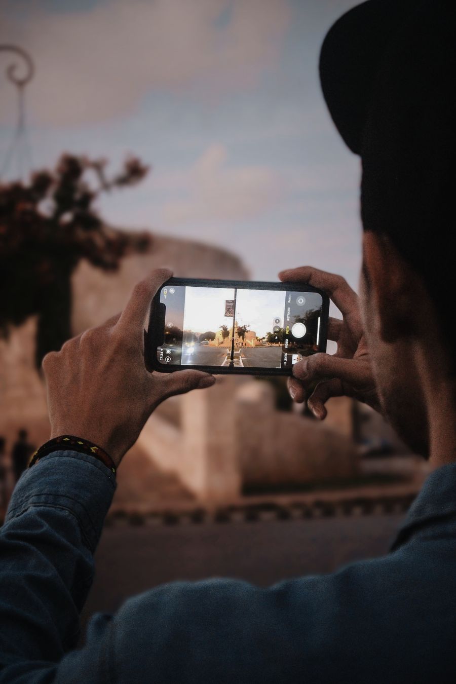 Man takes a photo of Mérida, Mexico with smartphone, capturing scenic view. — From question to next step: Find My Plan shortens the path to a decision.