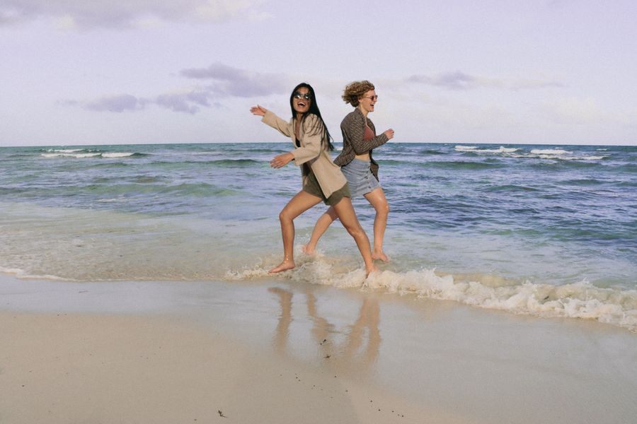 smiling women running on sea shore — Cafés-bureaux à Madagascar : partage stable, pas de roulette du Wi-Fi d'hôtel.
