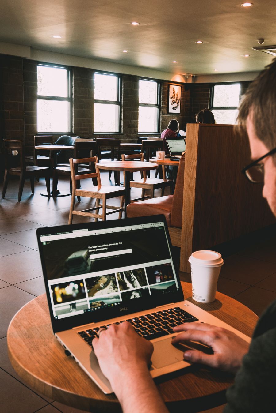 man using macbook on wooden table — Au niveau de la rue : navigation, VTC et avis, tout instantané.