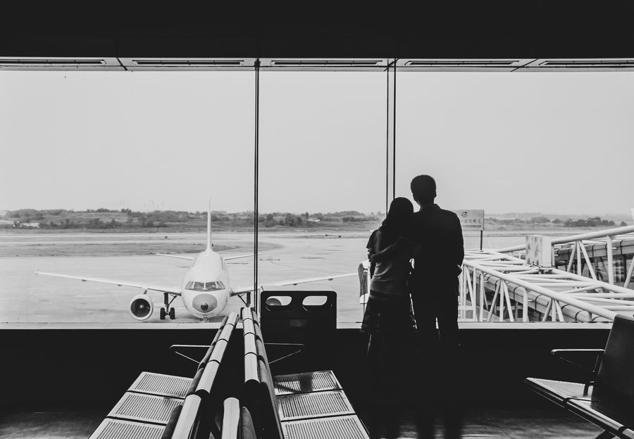 back view of couple embracing at airport — Chasse aux souvenirs à Senegal avec conversion de devises en direct dans la poche.