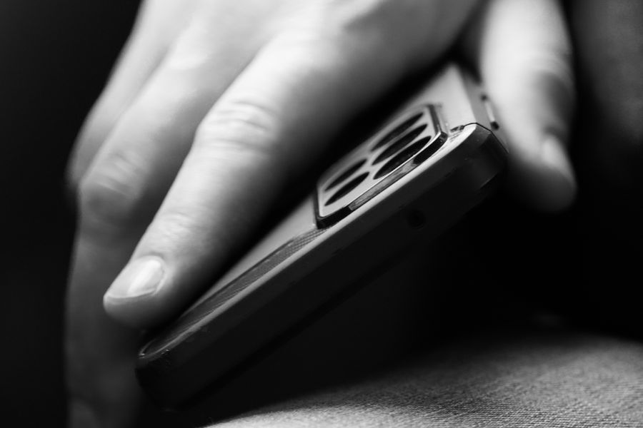 man holding mobile phone in black and white — From question to next step: Free Internet Speed Test shortens the path to a decision.