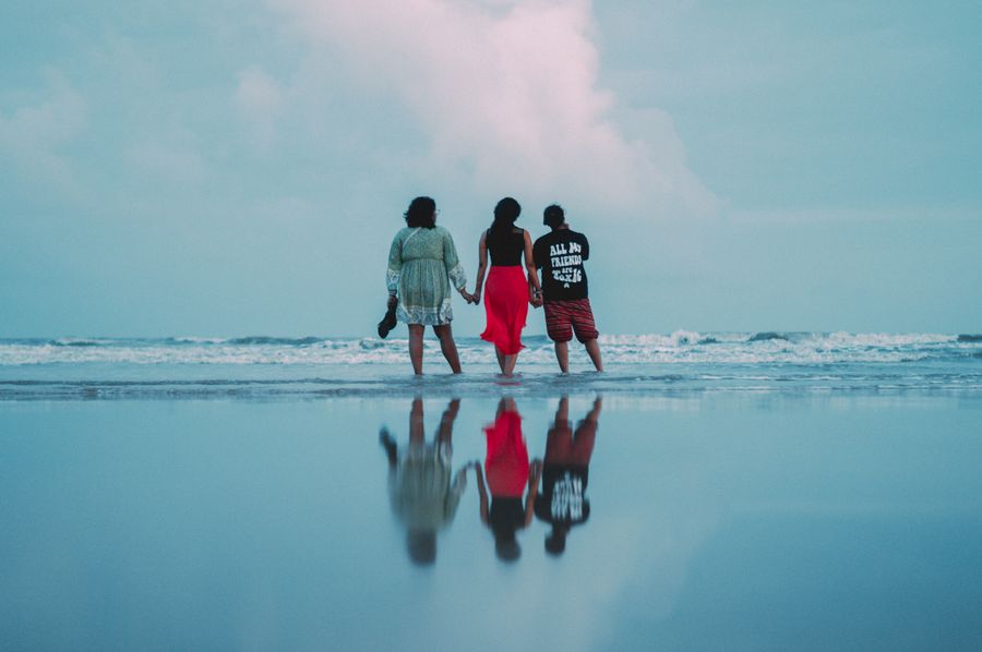 three people walking on the beach with the ocean in the background — Support: Pas de musique d'attente — la file est toujours vide.