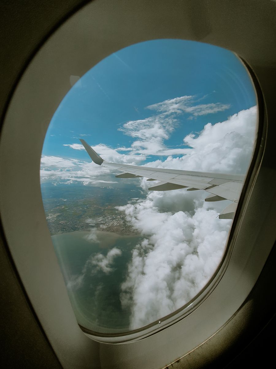 a view of the sky through an airplane window — La discussion de groupe reste active à chaque frontière franchie.