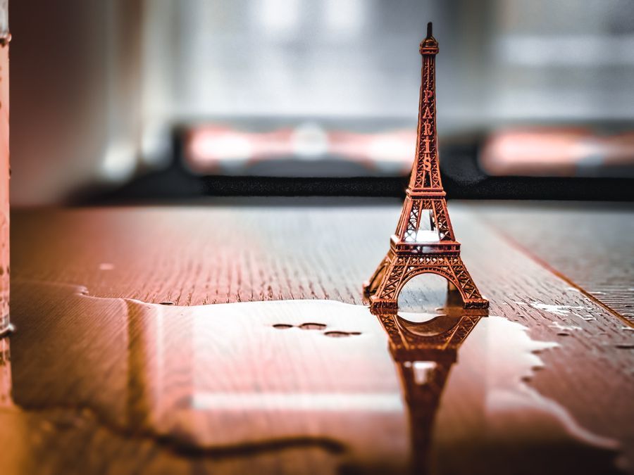 miniature eiffel tower reflected on wet surface