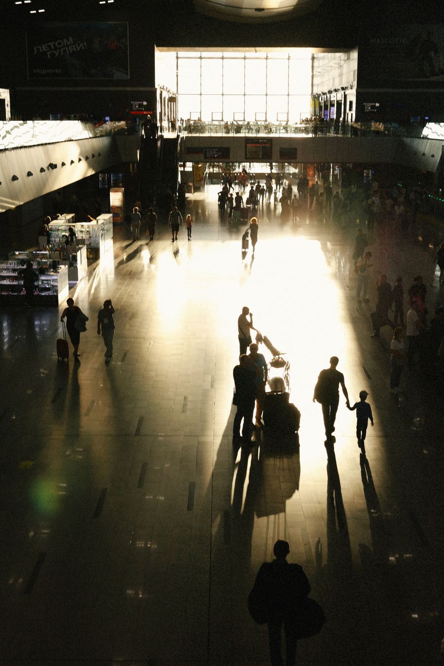 busy airport terminal with silhouetted travelers