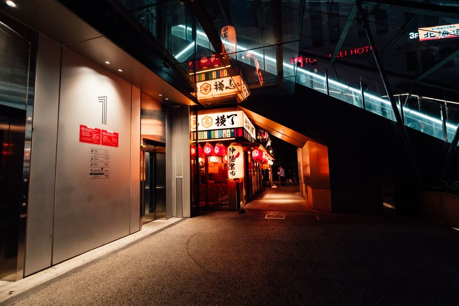 vibrant nightlife alleyway in japanese cityscape — Rooftop check-in: boarding passes and hotel keys, all on the phone.