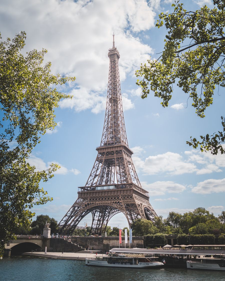 eiffel tower in paris on a sunny day — La poignée de main du comptoir de location : e-mail de confirmation ouvert, photo du permis prête.