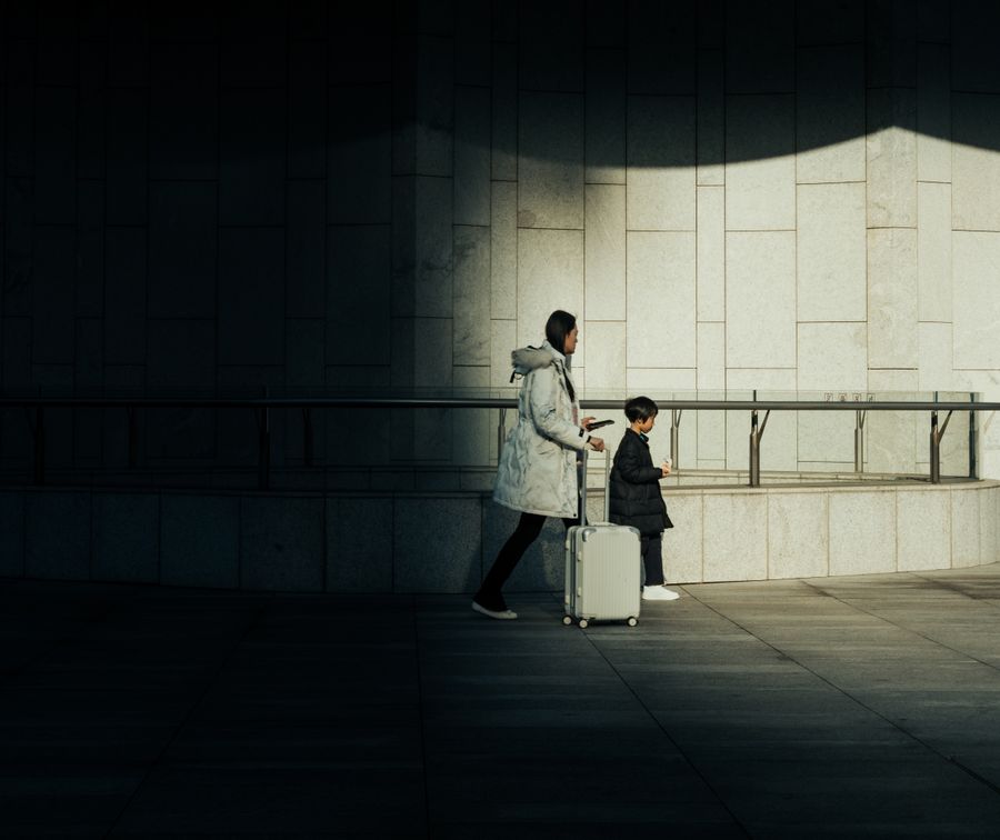 mother and child with suitcase walking indoors — Le quartier d'affaires de Morocco : le partage alimente toute la réunion.