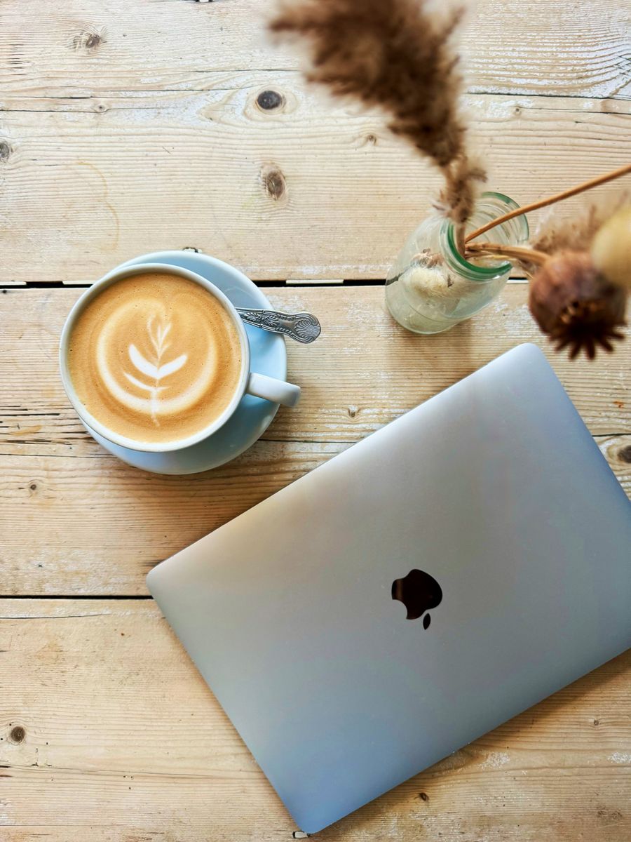 cozy cafe workspace with laptop and latte art — Trains de nuit à travers Rwanda : billets, horaires et taxis dans une main.