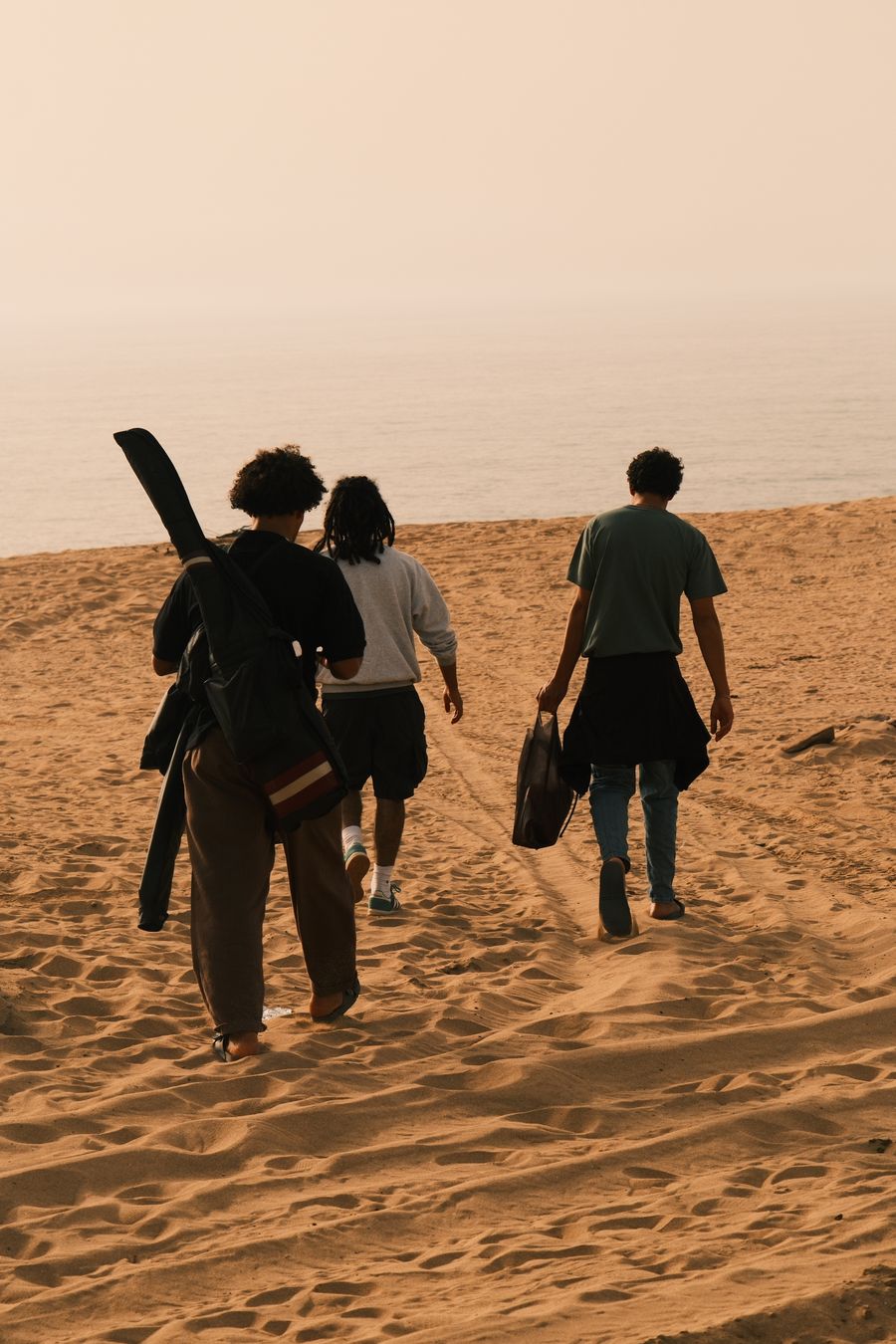three friends walking on a sandy beach at sunset — Developers: Chaque endpoint retourne la même forme — apprenez-en un, connaissez-les tous.