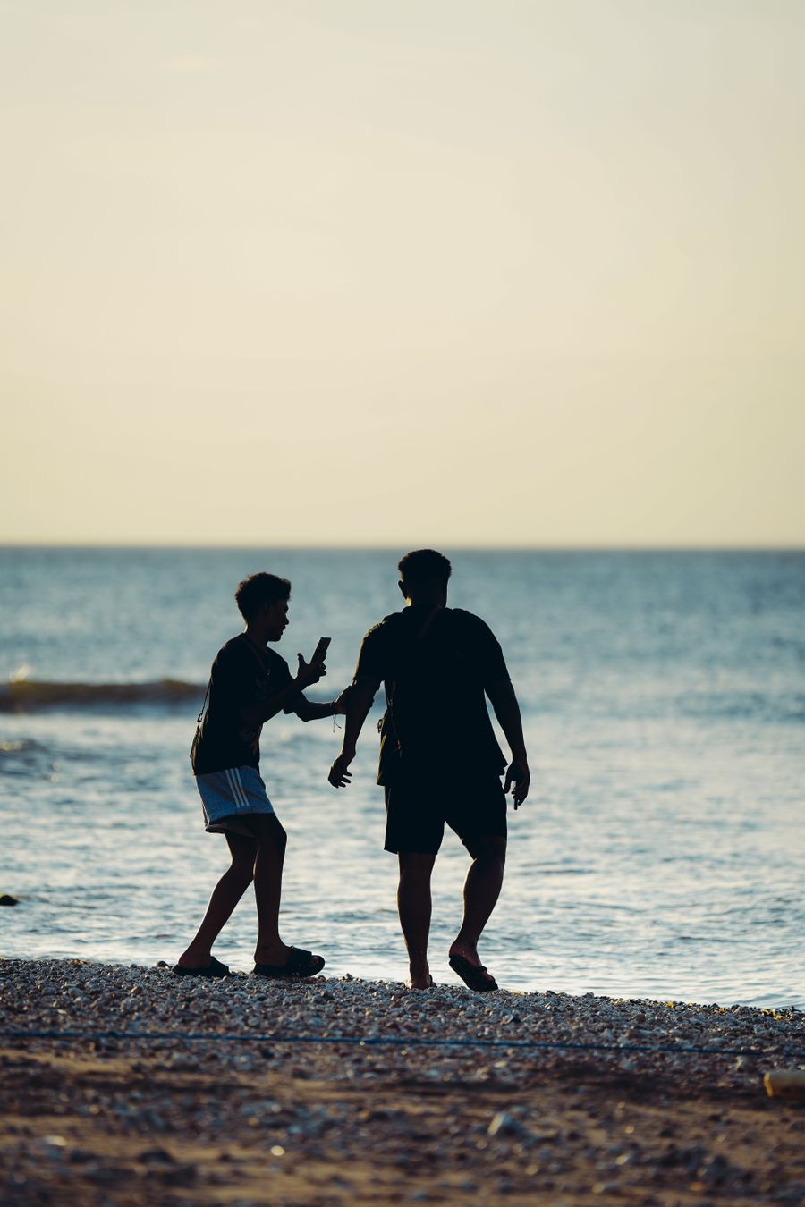 silhouette of two friends enjoying a beach sunset — Couverture, forfaits, dépannage — les trois choses qu'il fait bien.