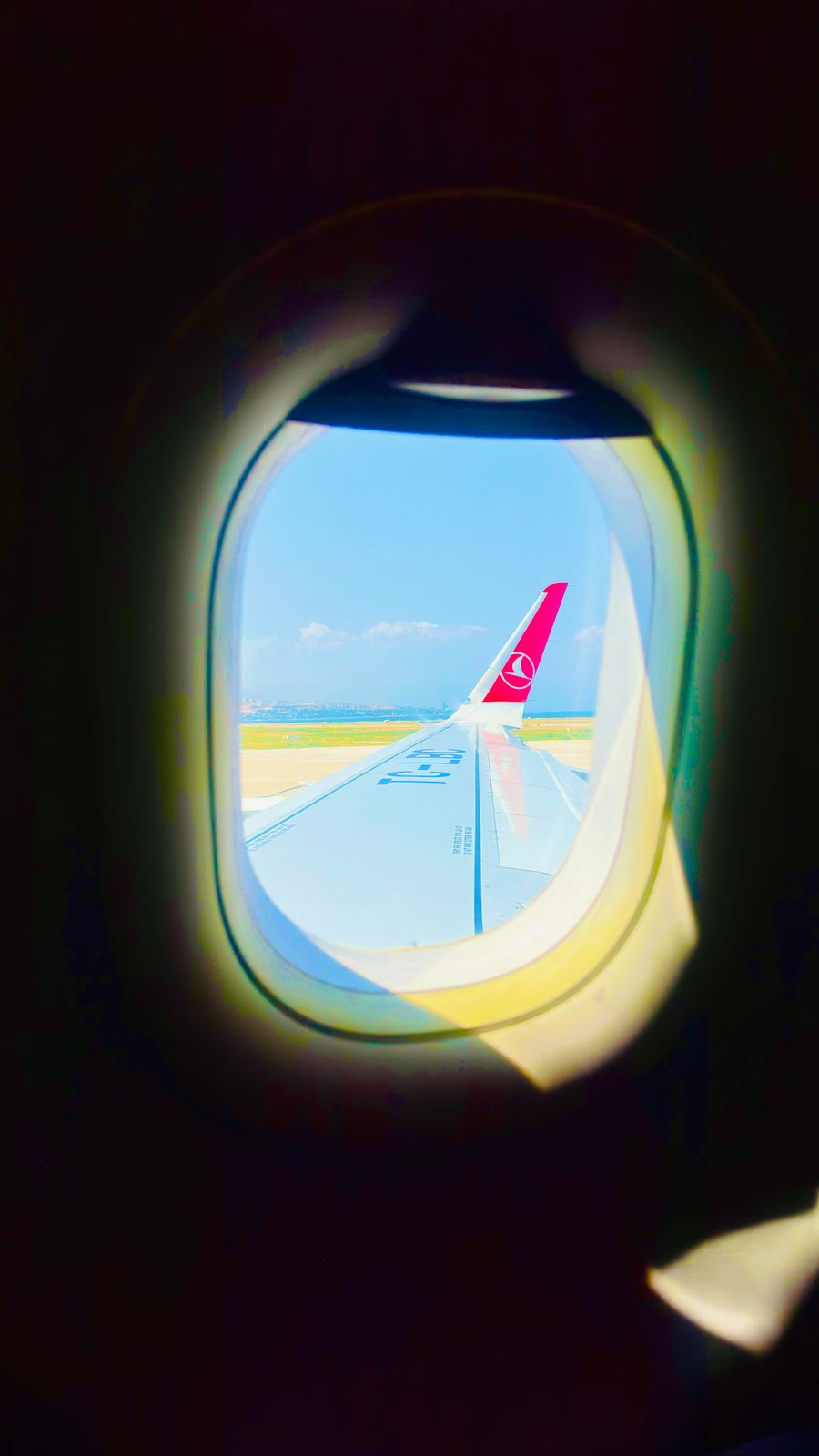 view from airplane window over turquoise skies — Le hall des arrivées de Madagascar : en ligne avant le tapis à bagages, à chaque fois.