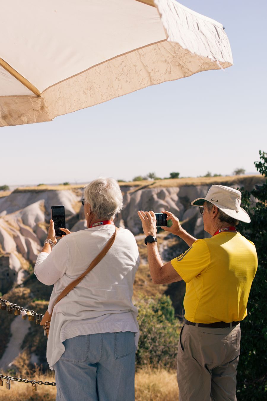 Senior tourists photographing scenic landscape in Cappadocia, Türkiye under a sun umbrella on a sunny day. — The spec grid shows exactly what Dialing Helper accepts and what it returns.