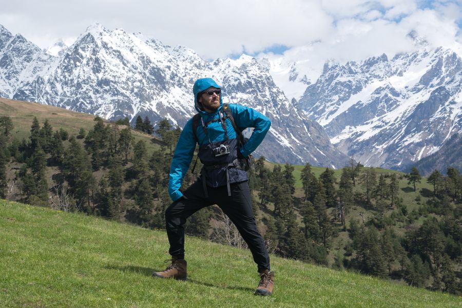man standing on a grass with snow covered mountains background — Sauts d'île près de Switzerland : ferries réservés, plages trouvées, signal plein.