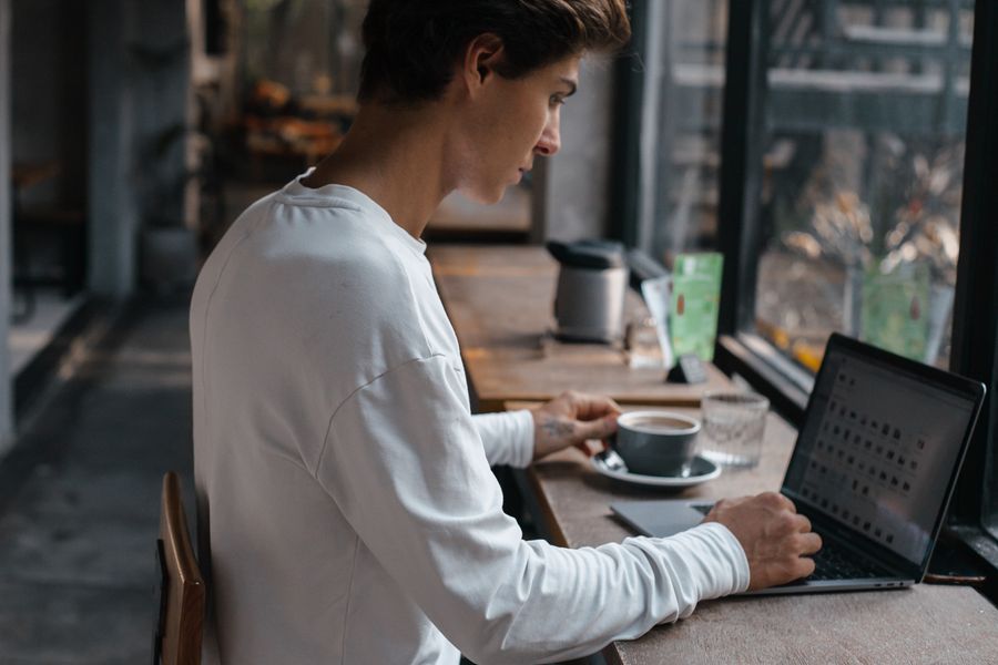 man working on laptop inside cafe — Les réponses de l'agent s'appuient sur les forfaits actuels — jamais de FAQ générique.