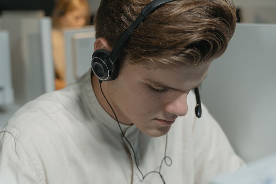 a man in white crew neck shirt wearing black headphones