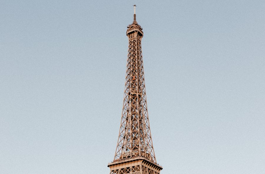 photo of the eiffel tower under a blue sky — Support: Café-bureau : partage actif, visio stable, pas de roulette du Wi-Fi d'hôtel.