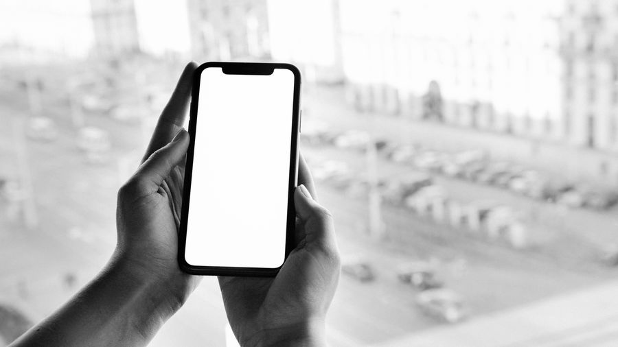 grayscale photo of person holding smartphone — Les discussions de groupe restent actives à chaque frontière autour de Côte d'Ivoire.
