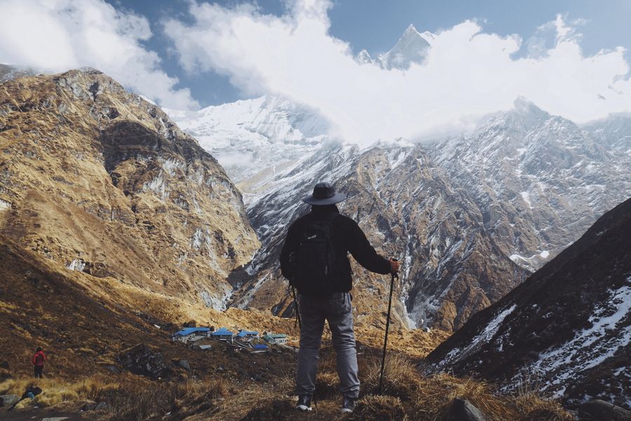 a man standing on a mountain — La skyline de Switzerland au crépuscule : appel vidéo à la maison avec toute la ville derrière.