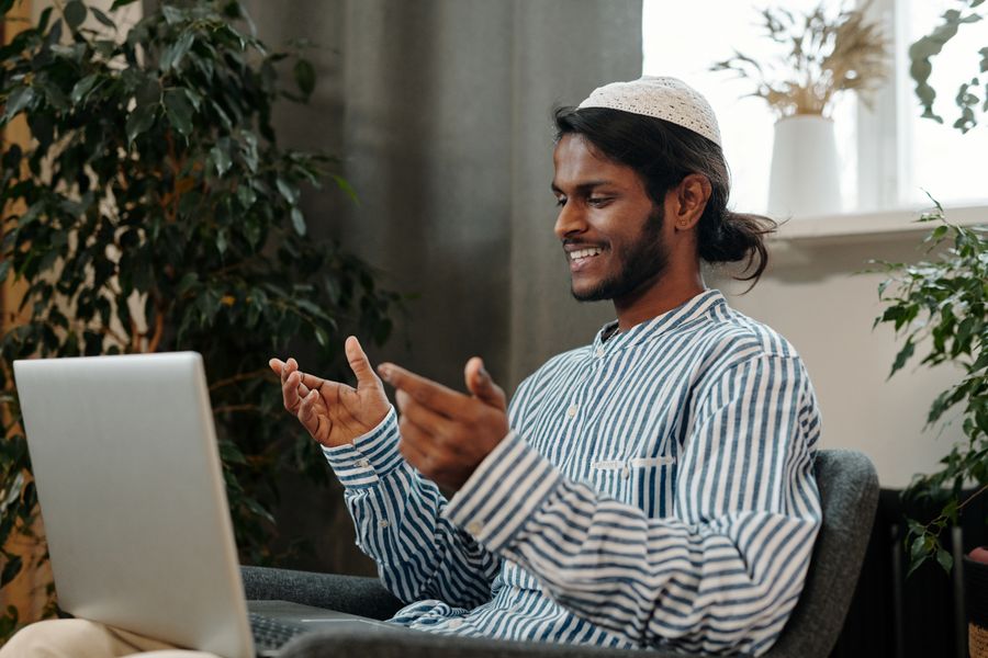man video calling using a laptop while sitting on a chair — Soirées à Burkina Faso : dîners, trajets et avis, tout instantané.