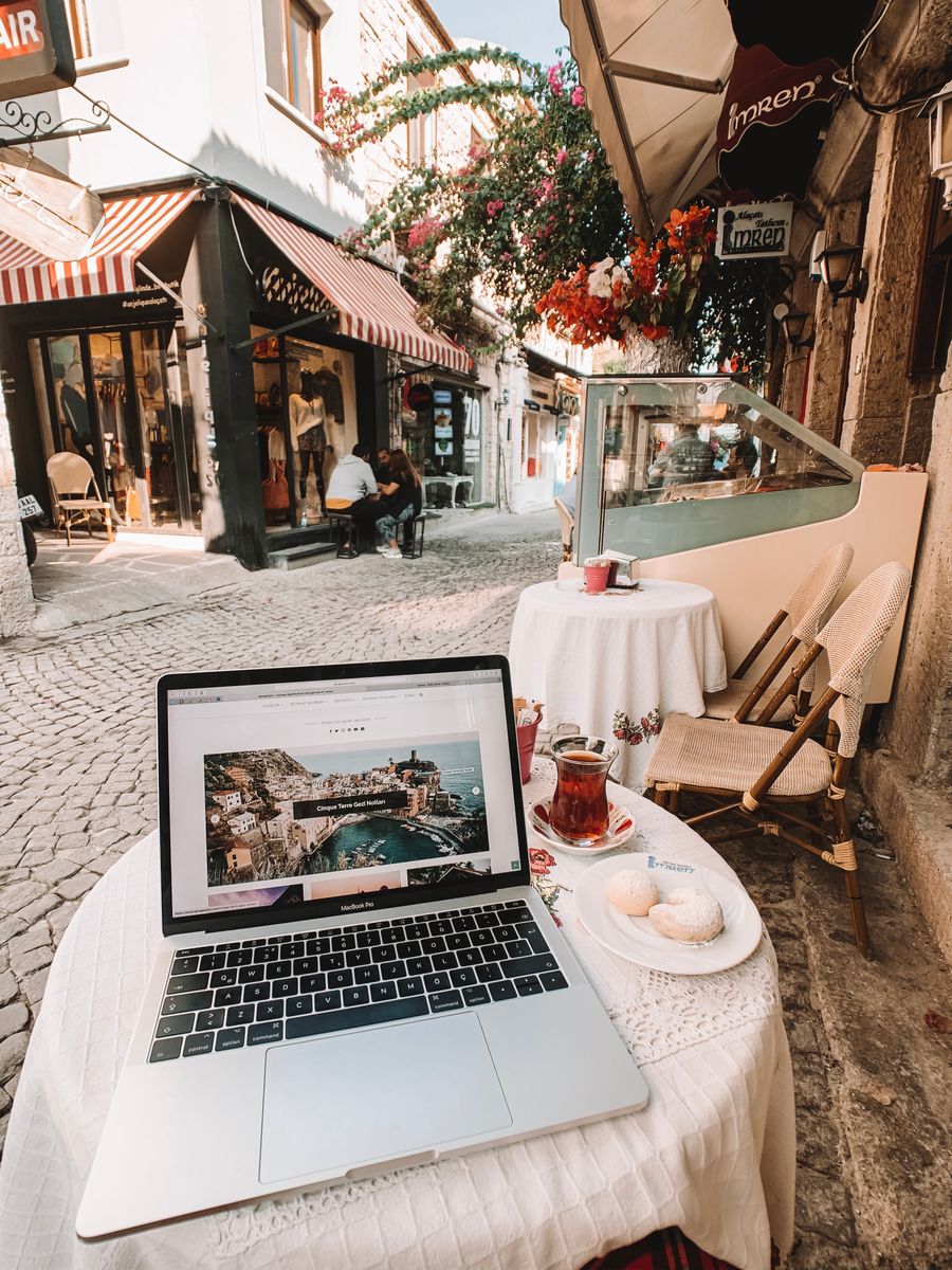 laptop standing on a table outside of a cafe with view of an alley — L'agent ne fait jamais de vente forcée ; il ajuste le forfait au voyage.