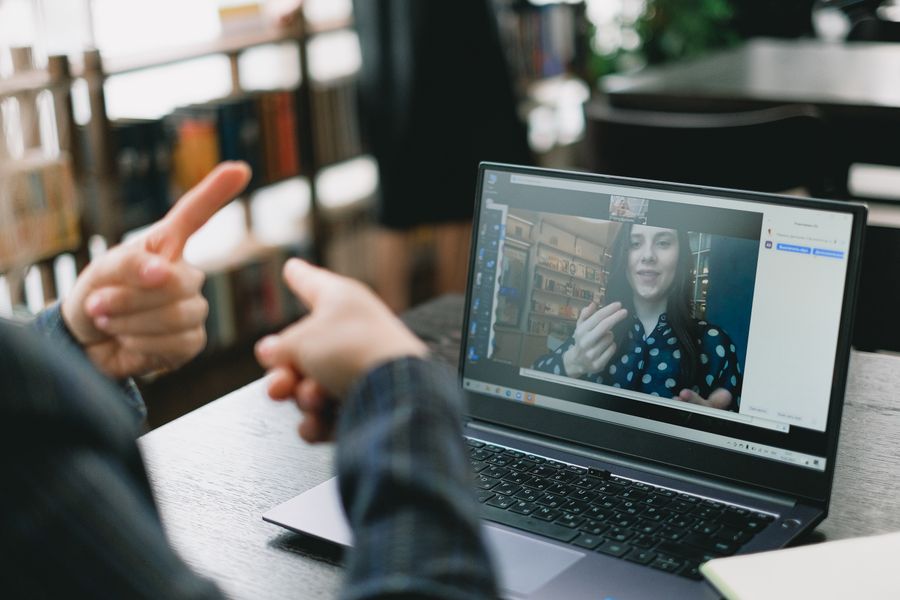 young lady learning sign language during online lesson with female tutor — Data Balance remembers, so repeat travelers barely type.