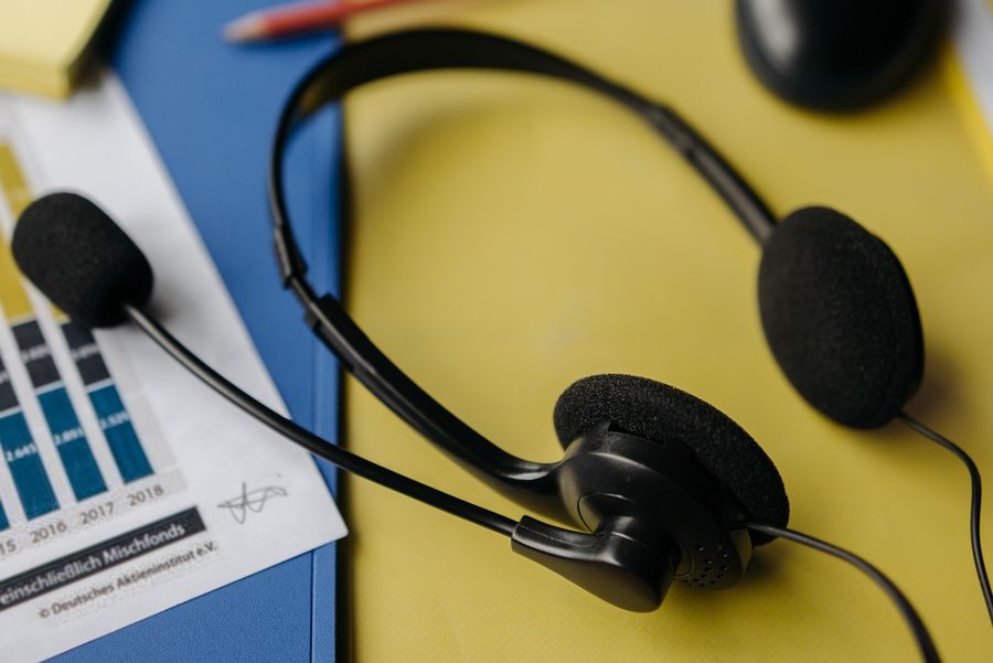 black headset on yellow file — Real journeys, real connectivity — this is what the product is for.