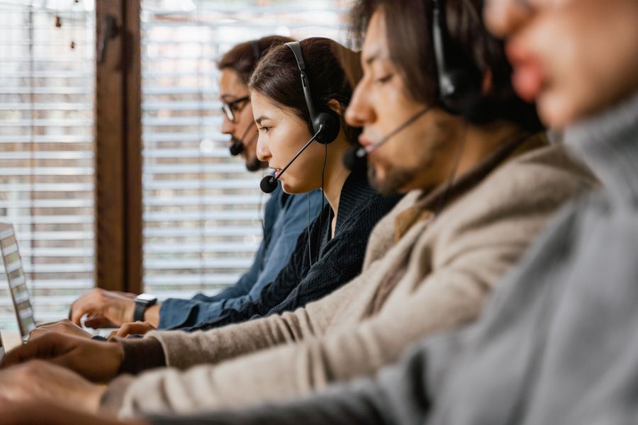 people working in a call center — Demandez la compatibilité eSIM — l'agent vérifie le modèle de votre téléphone.