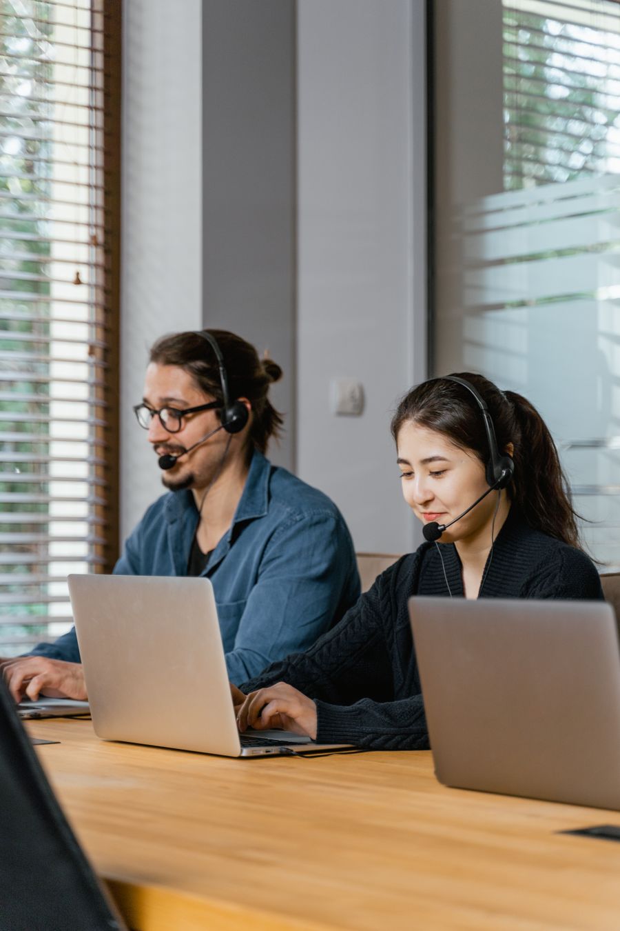 photo of a man in a blue shirt working beside a woman in a black top — Le badge de la conférence : billet QR scanné, programme synchronisé.