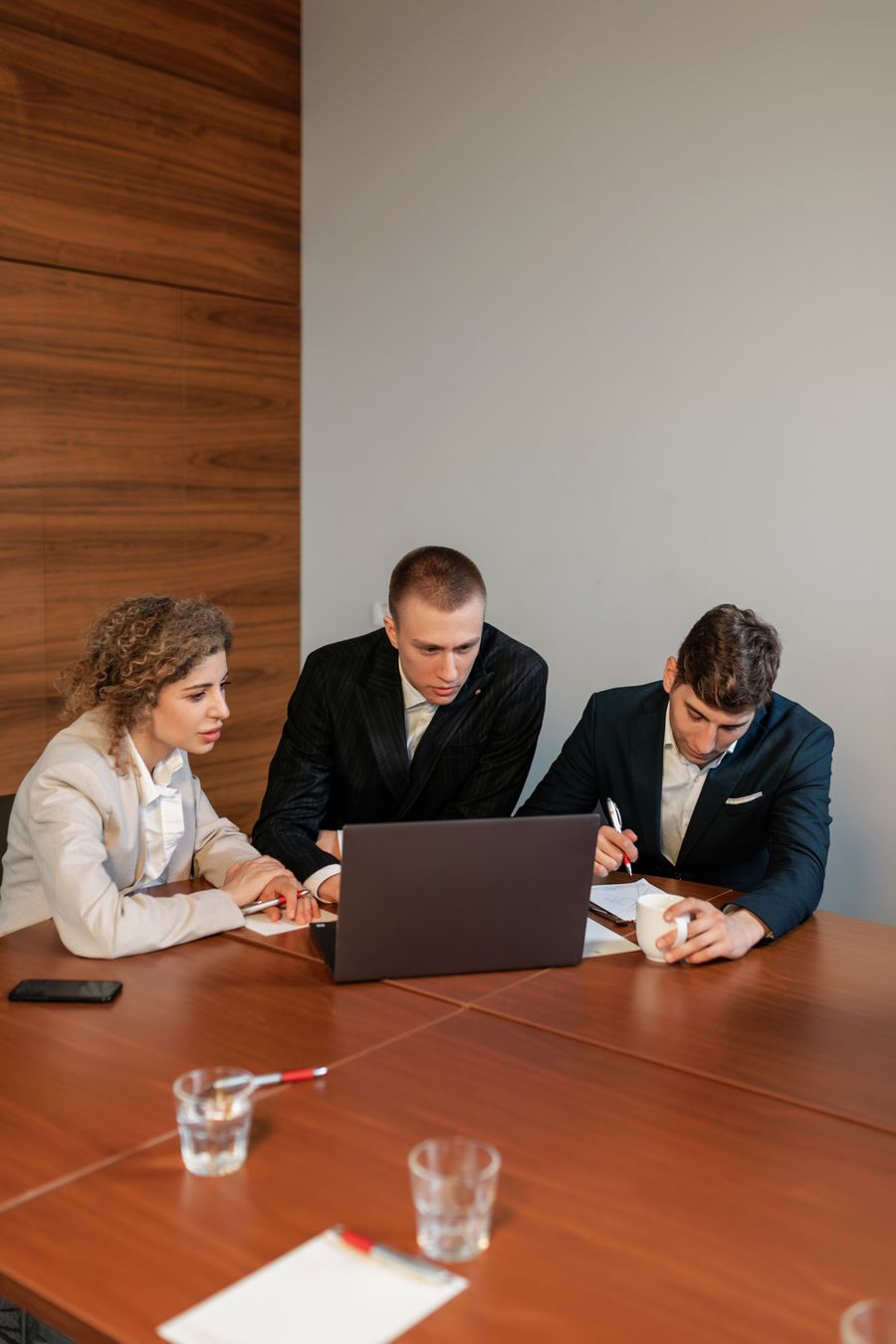 colleagues looking at a computer during a meeting — Pluie à Canada ? La connexion tient — la météo ne bride pas les données.