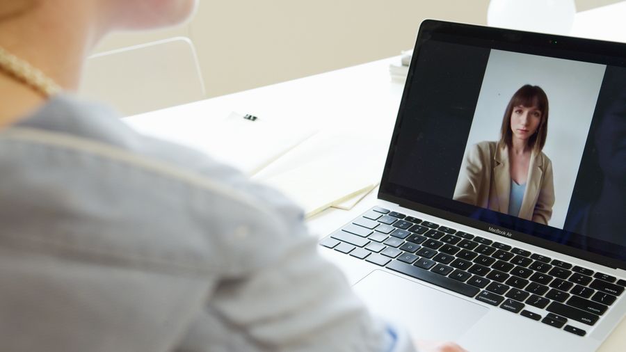 photo of a woman on the screen of a laptop — De quai en quai : billets, horaires et taxis dans une main.