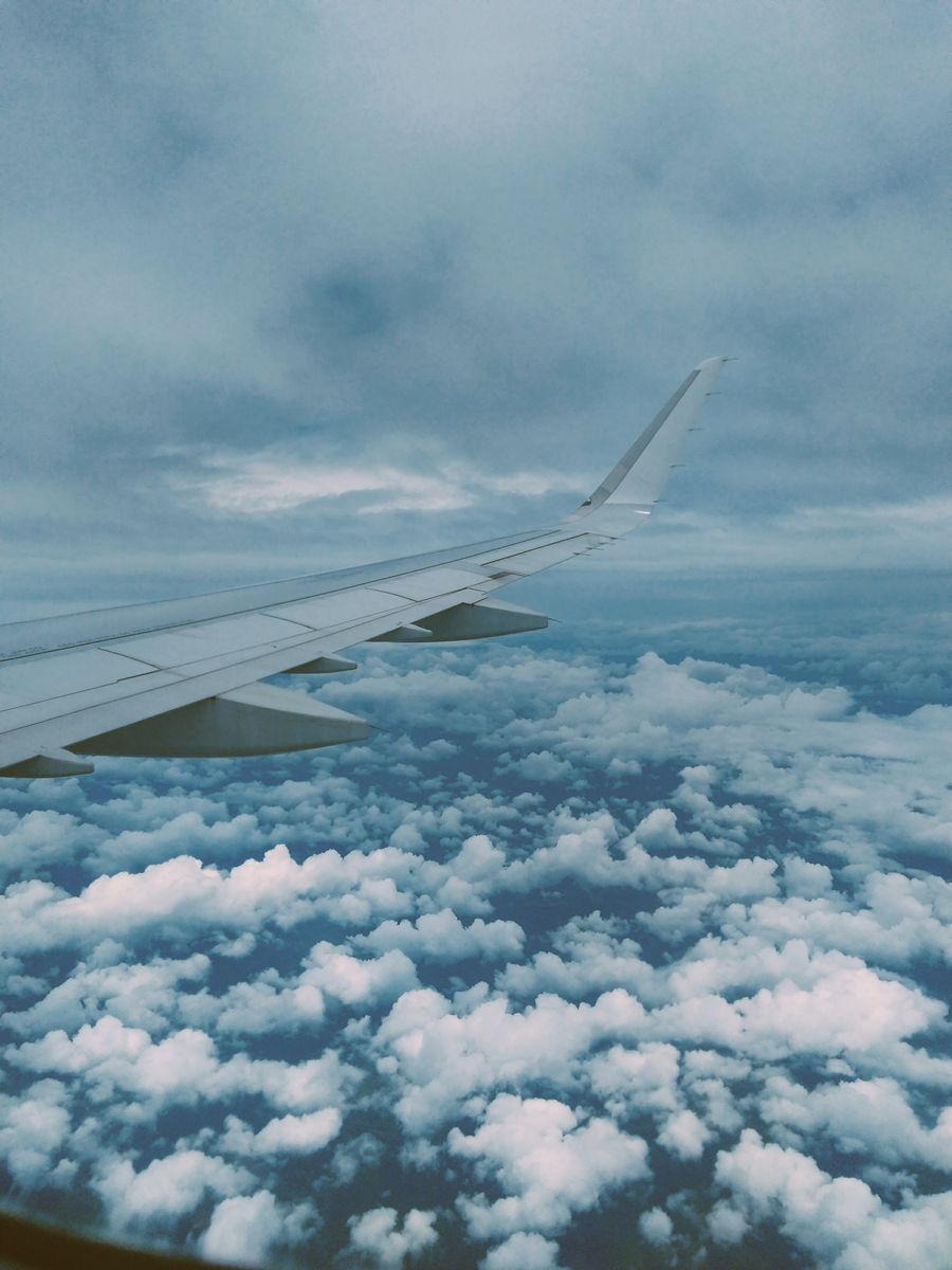 airplane wing and thick clouds — Jour du départ à Côte d'Ivoire : départ tardif demandé, taxi calé sur le vol.