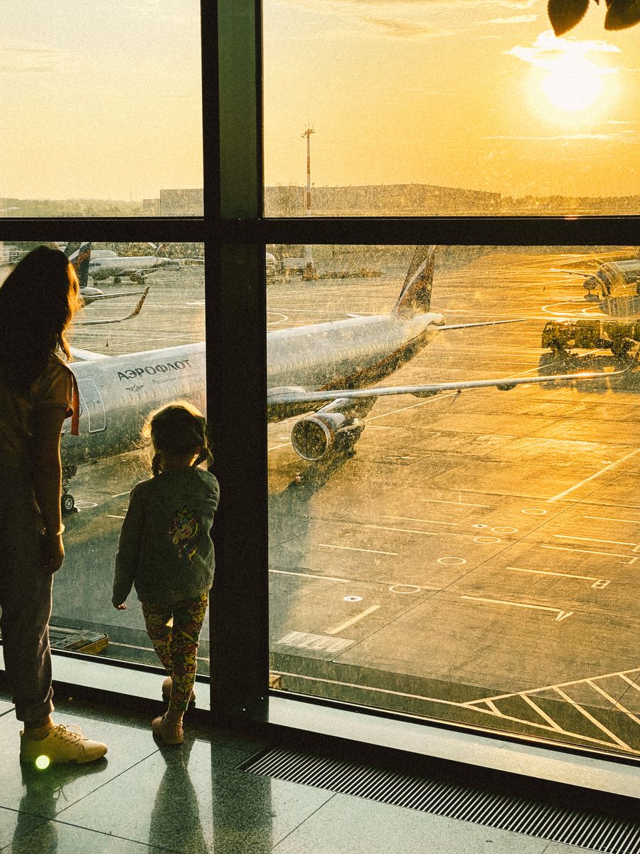 mother and daughter watching planes at an airport — eSIM Installation Guide links every answer onward — usually the plan it recommends.