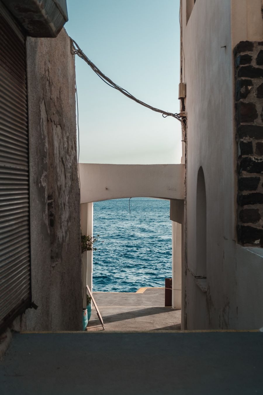 an empty alley near the ocean — Rainy-day backup plan: indoor attractions researched from the hostel bunk.